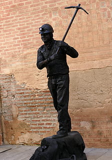 Bild, Statue, am Leben, Bergmann, Kohle, schwarz, Spitzhacke, Geld, verdienen, Tourismus, Malaga, Spanien, Lampe, Skulptur, menschliche Darstellung, Darstellung, männliche Ähnlichkeit, Kunst und Handwerk, die Architektur, Kreativität, Wand, Wandbau - Funktion, Gebäudehülle, Backstein, Tag, Ziegelwand, gebaute Struktur, Waffe, Kunst, Denkmal, keine Leute, Flachwinkelansicht, Regierung, 5K, CC0, gemeinfrei, lizenzfrei
