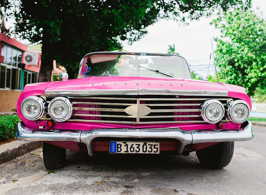 cotxe rosa, cotxe, automòbil, convertible, vehicle, transport, va parlar, Sedan, cotxe antic, suv, furgoneta, flora, planta, chevy rosa, cuba, impala rosa, cotxes de cuba, chevrolet, manera de transport, vehicle terrestre, estil retro, arbre, cotxe d'època, carrer, dia, ciutat, estacionari, color rosa, text, arquitectura, a l'aire lliure, vell, persones incidentals, luxe, 5K