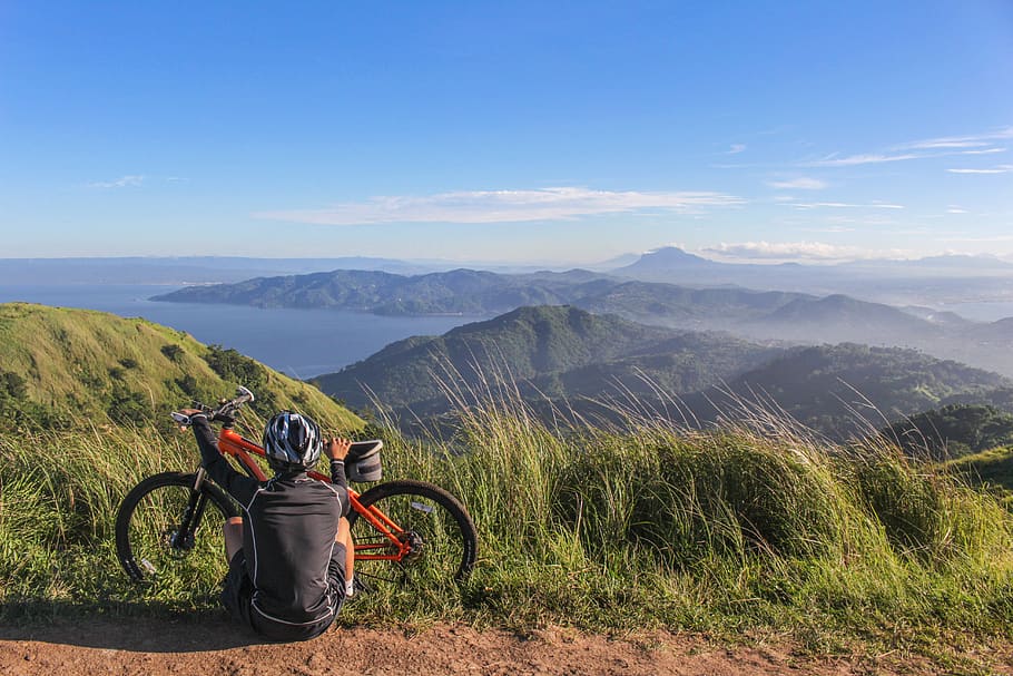 home, assegut, al costat, bicicleta, activitat, fons, motorista, cel blau, brillant, núvol, núvols, cloudscape, ennuvolat, cel ennuvolat, ciclisme, ciclista, dia, la llum del dia, medi ambient, aptitud, herba, pastures, verd, casc, alt, paisatge, bicicleta de muntanya, muntanyes, naturalesa, a l'aire lliure, persona, recreació, descans, carretera, escènic, cel, esport, sistema de transport, rodes, muntanya, escenics - natura, bellesa a la natura, escena tranquil·la, escena no urbana, tranquil·litat, transport, Serra, manera de transport, vehicle terrestre, idíl·lic, núvol - cel, activitat d'oci, planta, 5K