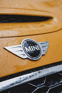 emblema mini cooper, marchio, simbolo, logo, orologio da polso, emblema, distintivo, pneumatico, parola, luce, faro, mobilia, cassetto, ufficio postale, maniglia, auto, auto sportiva, veicolo, automobile, mezzi di trasporto, armi, metallo, avvicinamento, nessuno, veicolo a motore, giallo, natura morta, modo di trasporto, color argento, vecchio, in casa, vista dall'alto, veicolo terrestre, giorno, concentrarsi sulle conoscenze acquisite, colore nero, numero, brillante, messa a fuoco selettiva, 4K, CC0, dominio pubblico, privo di copyright