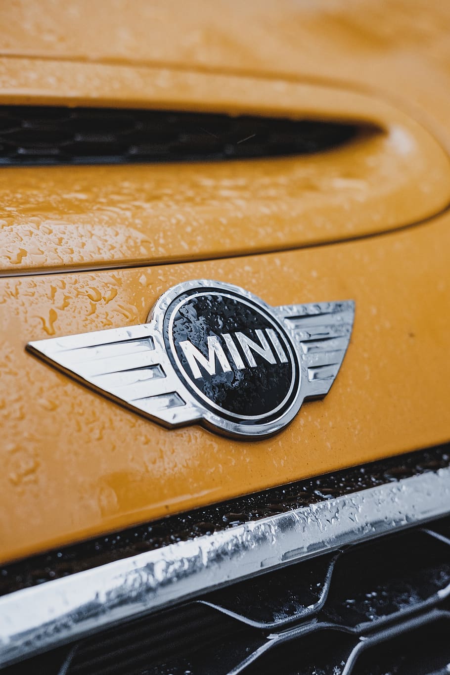 emblema de mini cooper, marca comercial, símbol, logotip, rellotge de polsera, emblema, insígnia, pneumàtic, paraula, llum, faro, mobles, calaix, oficina postal, gestionar, cotxe, cotxe esportiu, vehicle, automòbil, transport, armament, metall, primer pla, cap gent, groc, natura morta, manera de transport, color plata, vell, a l'interior, vista d’angle alt, vehicle terrestre, dia, centrar-se en primer pla, color negre, nombre, brillant, enfocament selectiu, 4K