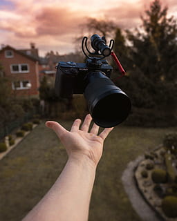 svart digitalkamera, sløret bakgrunn, kamera, kamera linse, skyet, enhet, digitalkamera, digital enhet, utstyr, fokus, hånd, landskap, moderne, person, himmel, teknologi, kasting, menneskelig hånd, menneskelig kroppsdel, én person, fokusere på forgrunnen, holding, ekte folk, arkitektur, personlig perspektiv, bygget struktur, fotografering temaer, kroppsdel, livsstil, ukjennelig person, natur, fritidsaktivitet, kamera - fotografisk utstyr, bygge eksteriør, utendørs, finger, menneskelig lem, 4K, CC0, offentlig domene, opphavsrett gratis