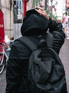 persona, portar, negre, dessuadora, de peu, carrer, vista posterior, motxilla, borrós, profunditat de camp, moda, focus, mà, vestit, carretera, urbà, desgast, ciutat, persones reals, roba, una persona, arquitectura, campana, persones incidentals, centrar-se en primer pla, vista del darrere, persona irreconeixible, estils de vida, estructura construïda, caputxa - roba, dia, color negre, exterior de l'edifici, cintura cap amunt, a l'aire lliure, cara oculta, roba calenta, 5K