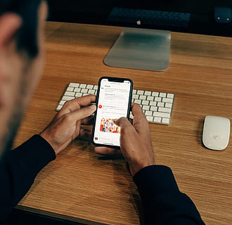 Mann, halten, Telefon, gelehnt, Tabelle, Technologie, Kommunikation, kabellose Technologie, Verbindung, eine Person, Computer, Erwachsene, drinnen, Männer, Geschäft, tragbares Informationsgerät, menschliche Hand, Arbeiten, Hand, menschliches Körperteil, High Angle View, Schreibtisch, Computer benutzen, über die schulter blick, 2K, CC0, gemeinfrei, lizenzfrei