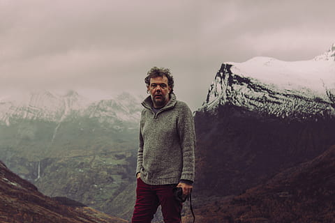 mand, stående, bjerg, tøj, beklædning, person, natur, human, udendørs, Geirangerfjord, norge, sweater, sne, portræt, grøn, vinter, grå, ærme, kigger ud, ældre, vinterlandskab, skønhed i naturen, scenics - natur, fritidsaktivitet, rigtige mennesker, en person, kigger på kameraet, bjergkæde, livsstil, ikke-urbane scene, sky - himmel, himmel, herrer, rolig scene, vandring, modne mænd, 5K, CC0, offentligt domæne, royaltyfrie