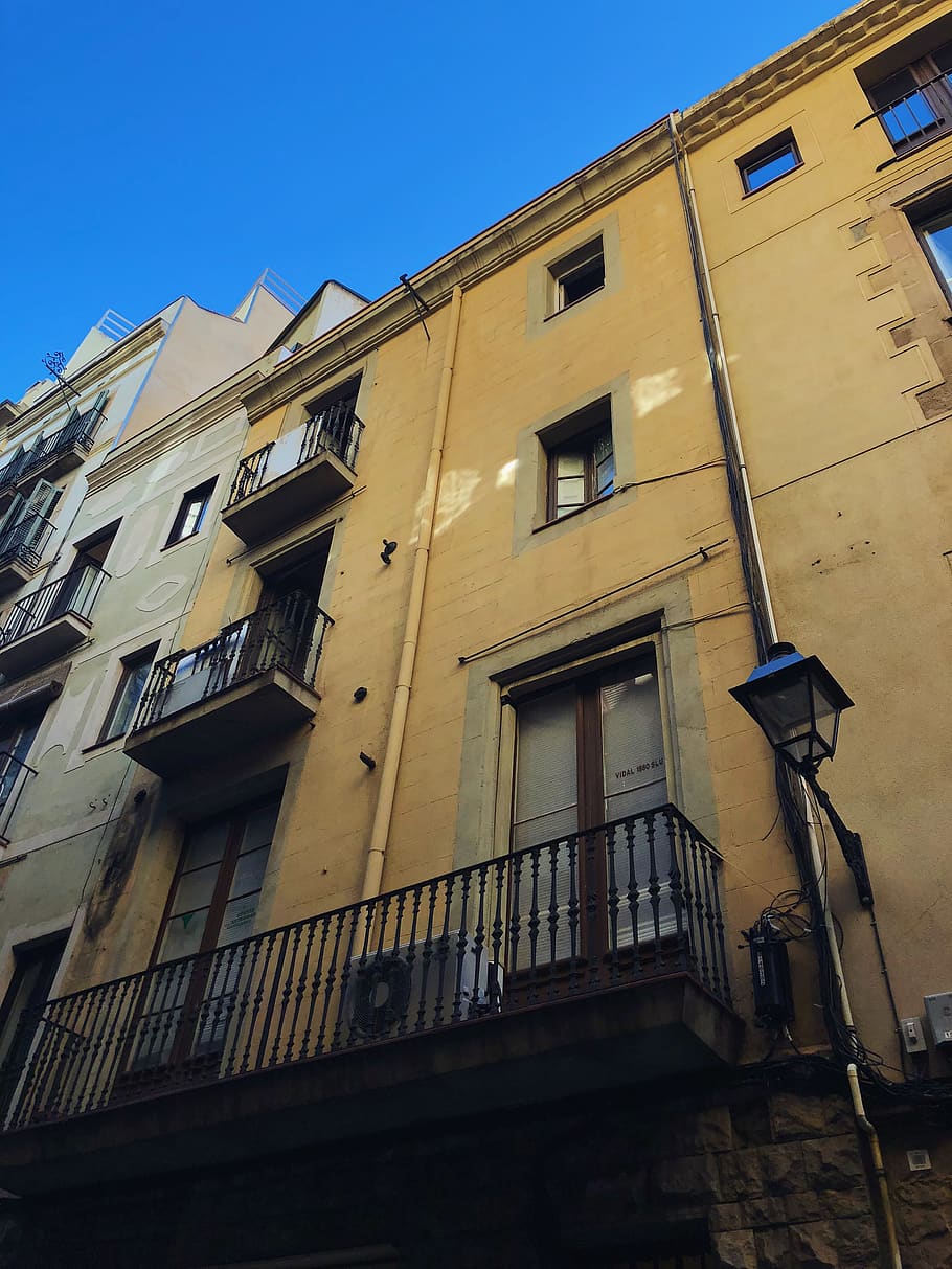 edifici pintat de color beix, urbà, edifici d'apartaments, edifici, ciutat, de gran alçada, espanya, carrer de santa anna, barcelona, habitatge, maó, barri, carrer, carretera, carreró, arquitectura, estructura construïda, exterior de l'edifici, vista d’angle baix, finestra, cel, barri residencial, cel clar, cap gent, dia, naturalesa, blau, a l'aire lliure, equips d’il·luminació, llum solar, barana, ombra, balcó, apartament, 4K