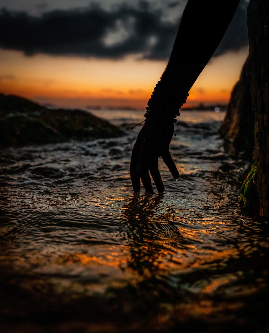silueta, persona, mà, tocar, aigua, posta de sol, retroil·luminat, platja, núvols, alba, vespre, tarda, horitzó, paisatge, oceà, a l'aire lliure, reflexió, escènic, mar, vora del mar, cel, sol, sortida del sol, viatjar, color taronja, núvol - cel, bellesa a la natura, persones reals, naturalesa, una persona, estils de vida, activitat d'oci, terra, part del cos humà, escenics - natura, part del cos, enfocament selectiu, 4K
