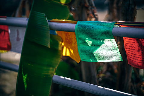 prayer flags, focus on foreground, day, close-up, green color, communication, outdoors, no people, text, nature, hanging, sunlight, red, protection, railing, metal, selective focus, flag, barrier, security, 5K, CC0, public domain, royalty free