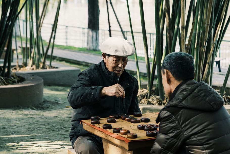 zwei, Männer, spielen, Brettspiel, Mensch, Person, Jacke, bekleidung, Kleidung, Mantel, Helm, Spiel, Schach, Holz, Ärmel, lange Ärmel, Domino, Finger, Musikinstrument, Musiker, Sitzung, Zimmermann, jugendlich, Kostüm, junge Männer, zwei Menschen, Zusammengehörigkeit, Freizeitbeschäftigung, echte Menschen, Freizeitspiele, Tag, Menschen, Legere Kleidung, Entspannung, Baum, Lebensstile, Erwachsene, draußen, warme Kleidung, 5K