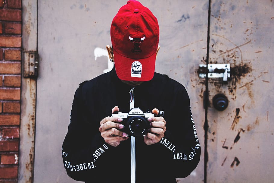 fotografie, osoba, hospodářství, Fotoaparát, Černá bunda, kamerové čočky, víčko, přístroj, dveře, elektronika, pokrývky hlavy, moderní, nikon, kamera nikon, snap, fotit, fotografování, technologie, městský, mít na sobě, jedna osoba, Červené, nástěnný prvek, čelní pohled, muži, pas nahoru, den, stojící, sdělení, skutečných lidí, text, k nepoznání člověka, mladého dospělého, volnočasové aktivity, dospělý, oblečení, bezpečnost, fotografická témata, zakryté tváře, 5K