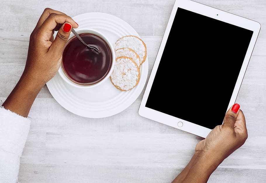 persona que sosté ipad, begudes, cafè, cookies, beure, electrònica, ipad, pantalla, tauleta, mà humana, mà, menjar i beguda, tassa, taula, part del cos humà, tassa de cafè, una persona, tecnologia sense fils, celebració, comunicació, cafè - beguda, vista d’angle alt, refresc, persones reals, a l'interior, plat, dit, vaixella, esmorzar, 5K