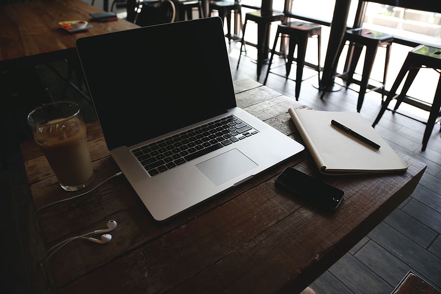 MacBook, portàtil, ordinador, taula, cafeteria, Café amb gel, Bloc de notes, bolígraf, iphone, mòbil, tecnologia, auriculars, negocis, tecnologia sense fils, comunicació, material de fusta, beure, menjar i beguda, connexió, cap gent, a l'interior, natura morta, refresc, dispositiu d’informació portàtil, tassa, mobles, vista d’angle alt, absència, equipament per a la llar, vidre, 5K
