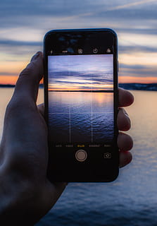 persona, detenzione, post-2014, iPhone post -2014, presa, foto, corpo, acqua, telecamera, telefono cellulare, nuvole, display, ora d'oro, mano, orizzonte, i phone, cellulare, oceano, all'aperto, Telefono, portatile, schermo, mare, paesaggio marino, scattare foto, tecnologia, visualizzazioni, senza fili, mano umana, tecnologia wireless, smart phone, temi fotografici, cielo, dispositivo di informazione portatile, comunicazione, una persona, Fotografare, persone reali, attività di svago, parte del corpo umano, parte del corpo, dito, orizzonte sull'acqua, 5K, CC0, dominio pubblico, privo di copyright