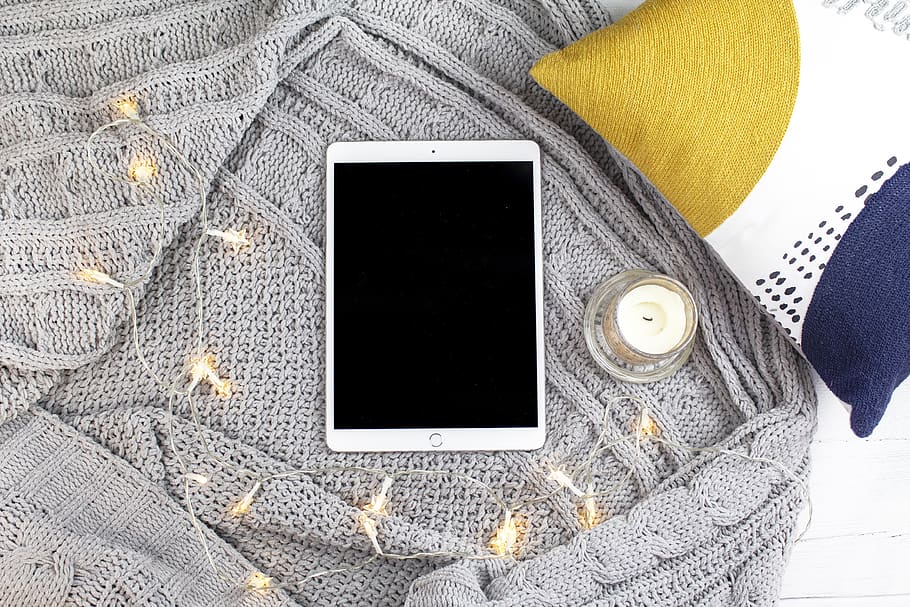 ipad de plata, coixí, decoració de la llar, vela, catifa, llibre, roba de llit, patró, groc, poma, treballant des de casa, disseny, bloc de vida, blogger de bellesa, blogger d’estil de vida, bloc, lancer, llums, llegir de casa, femení, comunicació, dispositiu d’informació portàtil, telèfon intel·ligent, tecnologia, telèfon mòbil, tecnologia sense fils, connexió, pantalla del dispositiu, pantalla, temes de fotografia, taula, a l'interior, una persona, pantalla tàctil, natura morta, primer pla, portabilitat, en blanc, accessori personal, 4K