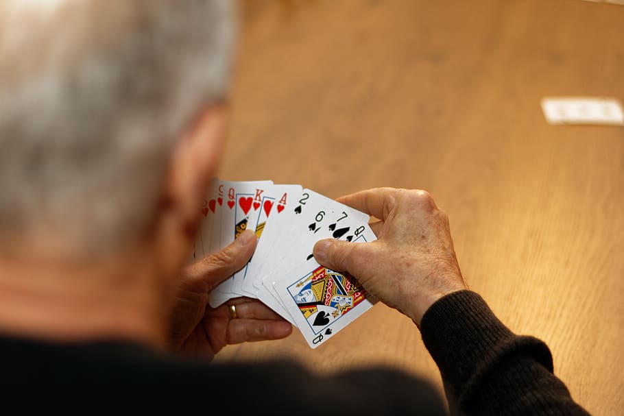 carte, vecchio uomo, mano, giocando, gioco di carte, giochi di svago, detenzione, gioco d'azzardo, una persona, mano umana, fortuna, uomini, adulto, rilassamento, attività di svago, in casa, cultura artistica e intrattenimento, retrovisore, tavolo, adulto senior, colpo alla testa, poker - gioco di carte, vista sopra la spalla, 5K