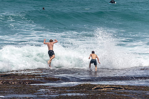 onades, nois, saltar, roques, oceà, aigua, mar, moviment, estils de vida, onada, activitat d'oci, persones reals, esport, dia, dues persones, naturalesa, homes, sense camisa, platja, gent, surf, escenics - natura, bellesa a la natura, esquitxades, a l'aire lliure, poder a la natura, 5K, CC0, domini públic, lliure de regalies