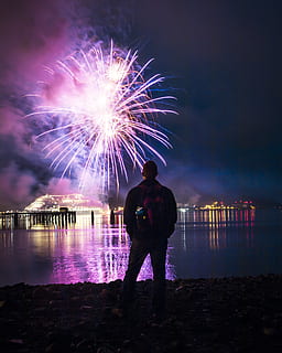 leder, mand, stående, ild, lys, lit, fyrværkeri, uafhængighed, fjerde juli, ser, eksplosion, alaska, nat, belyst, vand, himmel, fest, bagfra, rigtige mennesker, natur, kunstkultur og underholdning, bevægelse, en person, eksploderer, herrer, fuld længde, begivenhed, lang eksponering, udendørs, fyrværkeri - menneskeskabt objekt, gnister, kigger på visning, 4K, CC0, offentligt domæne, royaltyfrie