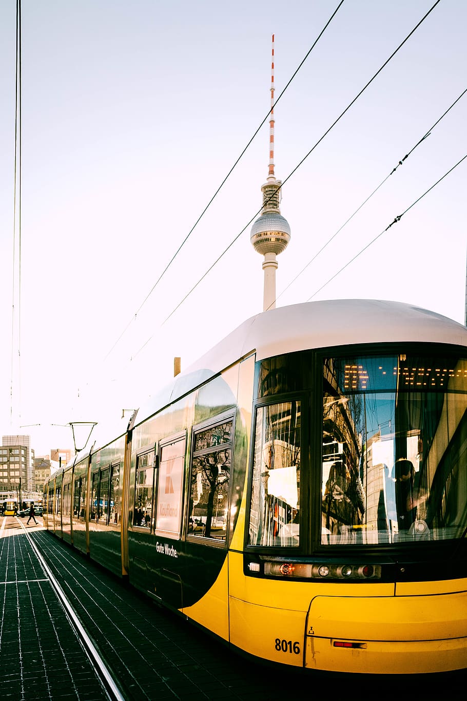 gult tog, Tyskland, Berlin, Alexanderplatz, transportmidler, svævebane, køretøj, by, by-, sporvogn, person, human, tog, bygning, metropol, trolley, kvarter, Spir, arkitektur, offentlig transport, transportform, bygget struktur, jernbanetransport, himmel, bygning udvendig, rejse, spore, jernbanespor, kabel, natur, dag, tog - køretøj, tårn, skyfri himmel, udendørs, ingen mennesker, elektricitet, station, 5K