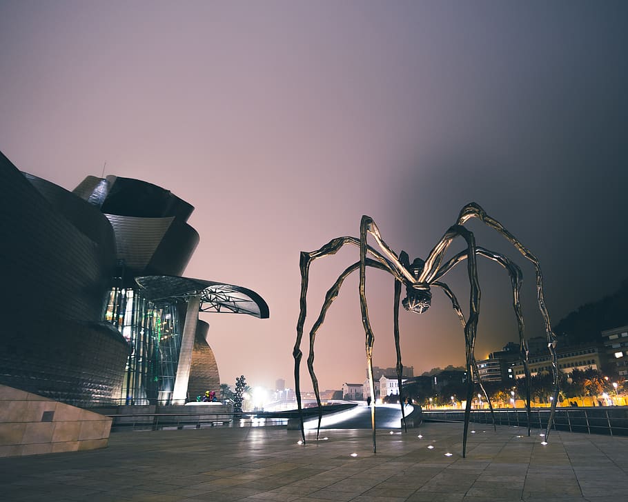 schwarze Spinnenstatue, Himmel, beleuchtet, die Architektur, gebaute Struktur, Gebäudehülle, Stadt, Transport, Straße, Natur, Strassenlicht, Nacht-, Kraftfahrzeug, Lichtanlage, Auto, keine Leute, Reiseziele, Transportmittel, modern, klarer Himmel, draußen, Bürogebäude außen, Wolkenkratzer, Licht, 4K