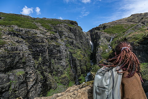 persona, indossare, Marrone, maglione, grigio, zaino, capelli dreadlocks, superiore, montagna, prospiciente, cascate, scogliera, nuvole, luce del giorno, ambiente, erba, escursionista, paesaggio, montagne, natura, fotografia naturalistica, rocce, panoramico, acqua, attività di svago, solido, roccia, retrovisore, pianta, cielo, roccia - oggetto, giorno, stili di vita, albero, persone, donne, capi di abbigliamento, scenics - natura, all'aperto, la tranquillità, scena non urbana, bellezza nella natura, 2K, CC0, dominio pubblico, privo di copyright