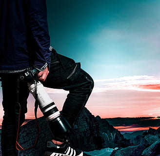 man, wearing, black, bomber jacket, denim jeans, holding, dslr camera, camera, clouds, fashion, jacket, lens, person, rocks, wear, young, real people, one person, sky, standing, casual clothing, lifestyles, leisure activity, cloud - sky, nature, men, photography themes, midsection, camera - photographic equipment, occupation, photographic equipment, technology, photographer, outdoors, digital camera, jeans, 1080P, CC0, public domain, royalty free