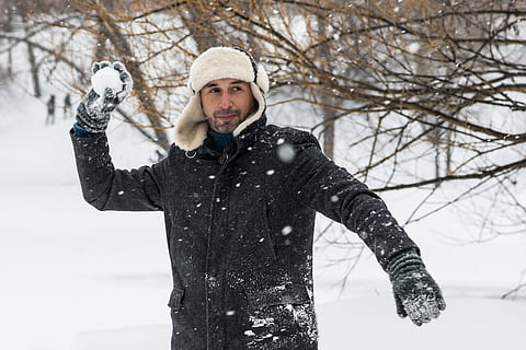 home amb bola de neu, abric, fred, medi ambient, zing, gelades, gelada, temps gelat, congelat, guants, paio, barret, gel, jaqueta, oci, masculí, home, naturalesa, recreació, temporada, neu, bola de neu, flocs de neu, tempesta de neu, nevat, llançar, temps, hivern, roba d'hivern, jaqueta d'hivern, temperatura de fred, una persona, roba calenta, roba, de peu, vista frontal, persones reals, mirant la càmera, homes, adult jove, mascles, retrat, dia, mig adult, arbre, nevar, a l'aire lliure, braç humà, 2K, CC0, domini públic, lliure de regalies