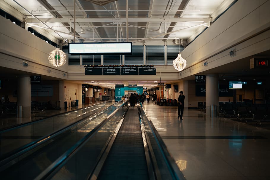 uomo, a piedi, dentro, costruzione, aeroporto, persona, umano, terminal dell'aeroporto, terminale, sentiero, passerella, atrio, camera, in casa, campo di aviazione, scrivania, mobilia, tavolo, abbraccio, pedone, sala, corridoio, centro Congressi, architettura, mezzi di trasporto, passerella mobile, viaggio, struttura costruita, persone accessorie, illuminato, convenienza, persone reali, modo di trasporto, soffitto, uomini, tecnologia, stili di vita, direzione, gruppo di persone, moderno, trasporto pubblico, 5K