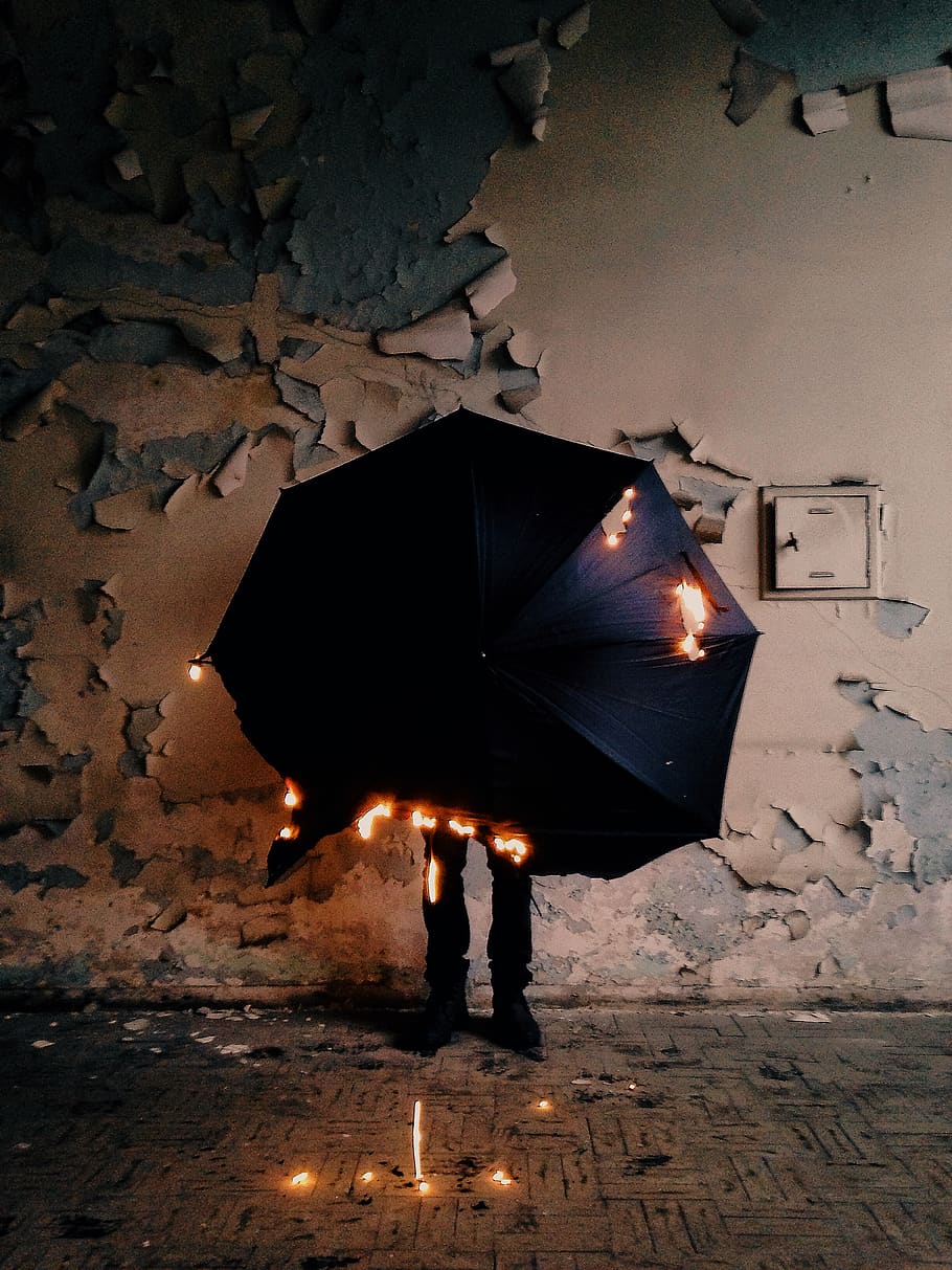 foto, cremant, paraigua, cremar, foc, flama, calor, calenta, a l'interior, paret, persones reals, una persona, il·luminat, nit, arquitectura, estils de vida, protecció, equips d’il·luminació, dones, longitud completa, naturalesa, estructura construïda, de peu, a l'aire lliure, activitat d'oci, brillant, 2K