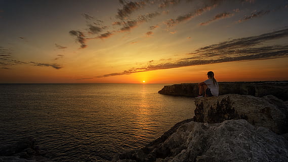 Foto, person, sidder, klippe, solnedgang, strand, skyer, daggry, miljø, horisont, idyllisk, fritid, natur, ocean, fredelig, lempelse, krusninger, klipper, landskab, naturskøn, hav, marinemaleri, kysten, sightseeing, sidde, himmel, sten, solopgang, rolig, vand, skønhed i naturen, horisont over vand, scenics - natur, sky - himmel, en person, jord, rock-objekt, fritidsaktivitet, orange farve, ro, solid, udendørs, kigger på visning, 5K, CC0, offentligt domæne, royaltyfrie