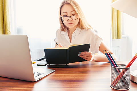 young, woman, make, notes, diary., laptop, pencils, table, front, computer, wireless technology, technology, using laptop, connection, communication, eyeglasses, glasses, one person, women, working, indoors, office, businesswoman, adult, business, concentration, hair, hairstyle, 5K