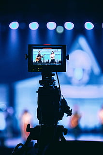 Videokamera-Aufnahme, Kunst, Kultur und Unterhaltung, Technologie, drinnen, beleuchtet, Fokus auf den Vordergrund, Nahansicht, Dreharbeiten, Musik-, Fotografie-Themen, Performance, Fernsehstudio, Fernsehkamera, Stativ, Lichtanlage, Filmindustrie, Fernsehgerät, Menschen, Tabelle, Studio, Bühne - Aufführungsraum, Bühne, Video, Heimvideokamera, Fernseh Show, Digitalkamera, 5K, CC0, gemeinfrei, lizenzfrei