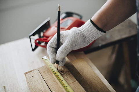 person, holding, black, pencil, builder, building, carpenter, carpentry, craft, cutter, glove, hand, indoors, instrument, length, measure, measurement, measuring, measuring tape, plank, power tool, saw, skill, tape measure, tool, wood, workshop, wood - material, human hand, one person, human body part, working, work tool, accuracy, close-up, focus on foreground, occupation, cutting, men, hand saw, 5K, CC0, public domain, royalty free