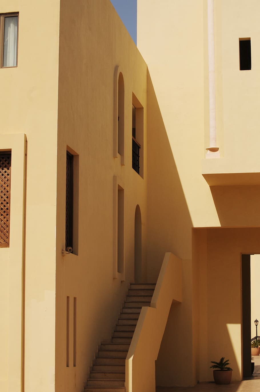 pintura de paret beige, arquitectura, estructura construïda, exterior de l'edifici, edifici, cap gent, finestra, escala, barri residencial, passos i escales, llum solar, a l'aire lliure, dia, barana, naturalesa, cel clar, equips d’il·luminació, funció de construcció de parets, vista d’angle baix, porta, direcció, funció de construcció, apartament, 2K