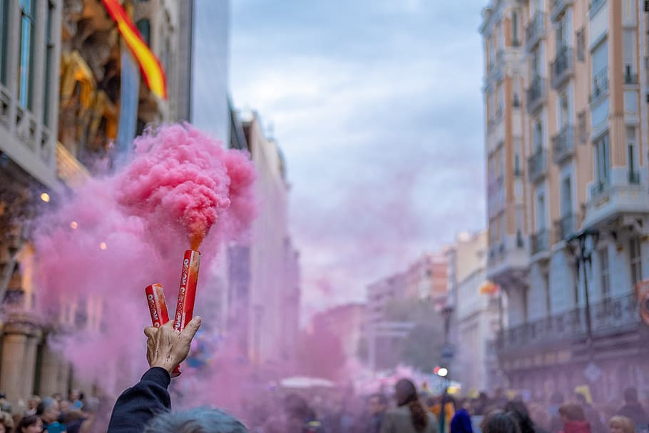 persona, celebració, rosa, fum, protesta, manifestació, multitud, carrer, ciutat, Bengala, fumar una bomba, granada de fum, fum de color rosa, mà, grup de persones, dia, gent, mà humana, persones reals, part del cos humà, arquitectura, persones incidentals, centrar-se en primer pla, esdeveniment, tirada al cap, holi, retrat, braç humà, extremitat humana, braços aixecats, 5K