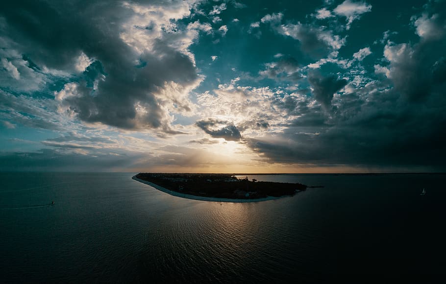 illa entre l’oceà, platja, núvols, alba, tarda, tret d'angle alt, oceà, reflexió, mar, paisatge marí, cel, sol, posta de sol, aigua, núvol - cel, bellesa a la natura, horitzó sobre l’aigua, escenics - natura, horitzó, escena tranquil·la, vaixell nàutic, tranquil·litat, naturalesa, transport, cap gent, idíl·lic, a l'aire lliure, manera de transport, 8K