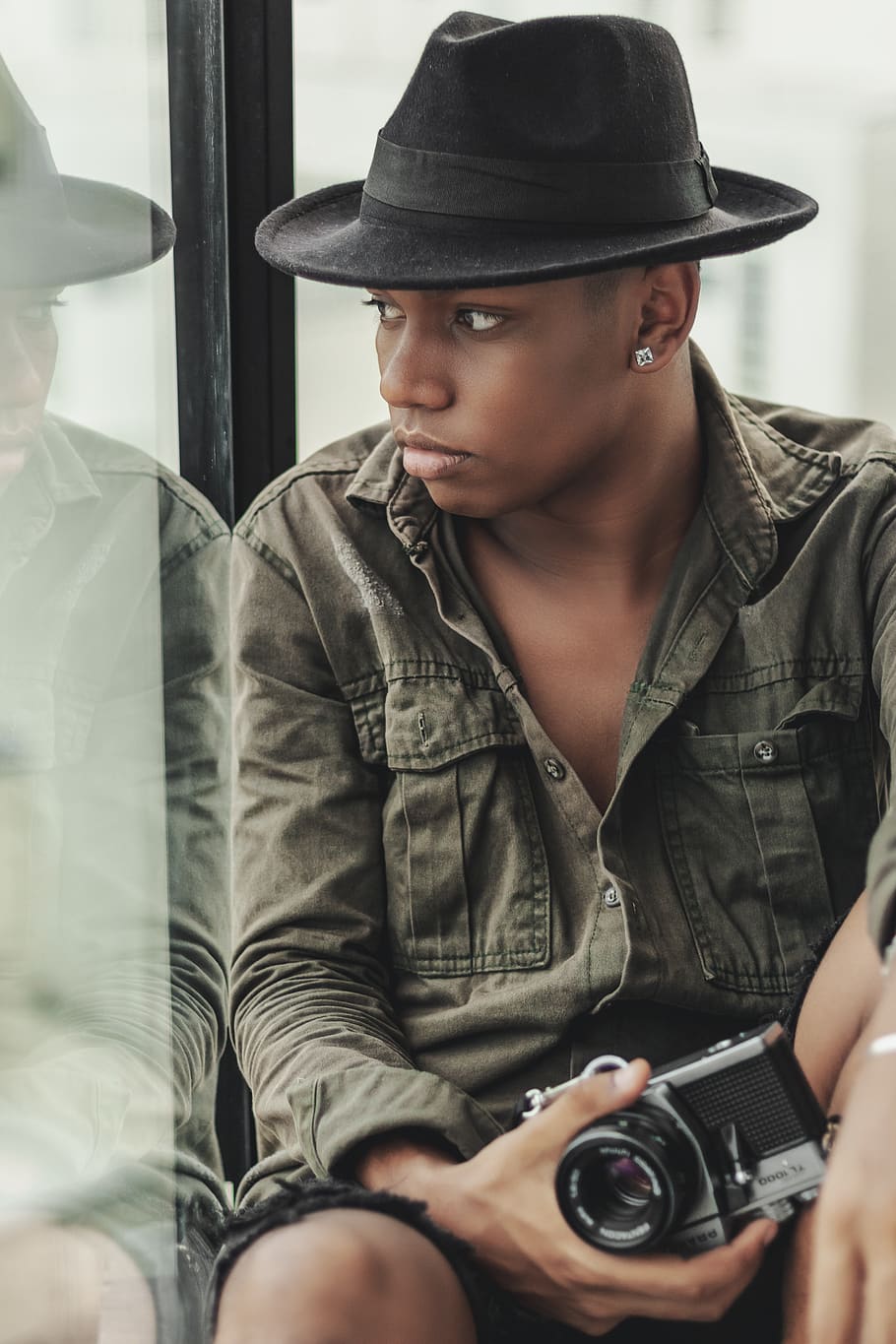 home, portar, camisa de vestir, celebració, càmera, dispositiu, electrònica, moda, fedora, inclinat, mirant cap a fora, masculí, model, modern, sessió de fotos, reflexió, reflexiu, assegut, tecnologia, desgast, persones reals, roba, càmera - equip fotogràfic, temes de fotografia, barret, adult jove, home jove, una persona, estils de vida, vista frontal, roba casual, retrat, mirant, fotografiar, activitat d'oci, activitat, fotògraf, contemplació, càmera digital, 5K