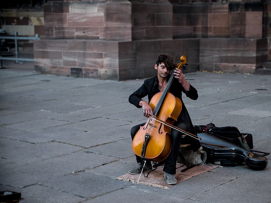 člověk hraje violoncello, jedna osoba, skutečných lidí, hudba, hudební nástroj, hraní, hudebník, strunný nástroj, sedící, město, plná délka, umělec, hudební vybavení, pouliční umělec, umělecká kultura a zábava, pouliční muzikant, ulice, den, architektura, hospodářství, venku, dlažební kámen, cellista, 4K