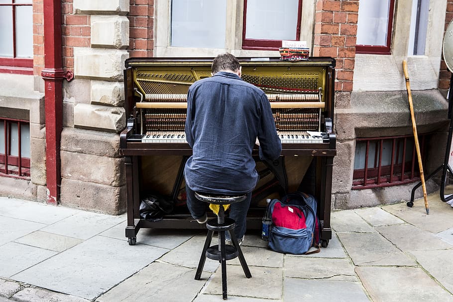 home interpretant el piano, una persona, persones reals, vista del darrere, música, instrument musical, equipament musical, exterior de l'edifici, homes, longitud completa, dia, arquitectura, estructura construïda, assegut, piano, cultura i entreteniment artístic, finestra, roba casual, ciutat, carrer, 5K