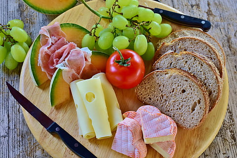 chleb, przekąska, ser, melon, szynka, winogrona, pomidory, jeść, jedzenie, odżywianie, wypieki, głód, kuchnia, gotowanie zdjęcia żywności, jedzenie i picie, zdrowe odżywianie, owoc, świeżość, dobre samopoczucie, kawałek, warzywo, pomidor, wysoki kąt widzenia, martwa natura, mięso, wybór, stół, wewnątrz, zmiana, drewno - materiał, deska do krojenia, żadnych ludzi, posiłek, przygotowanie, śniadanie, 4K, CC0, domena publiczna, darmowe zdjęcia