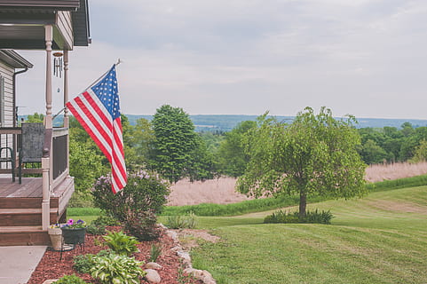 usa flag, white, house patio, American flag, daylight, grass, plant, patriotism, tree, sky, flag, nature, growth, day, cloud - sky, pride, striped, no people, beauty in nature, green color, emotion, outdoors, sunlight, wind, 4K, CC0, public domain, royalty free