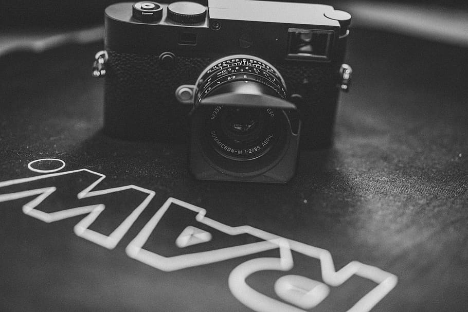càmera dslr negra, electrònica, càmera, càmera digital, corretja, leica, marca comercial, logotip, símbol, tapa de lent, lent de la càmera, càmera de vídeo, estèreo, publicitat, pòster, collage, ceràmica, roda, roda d'aliatge, màquina, va parlar, tecnologia, temes de fotografia, primer pla, càmera - equip fotogràfic, a l'interior, cap gent, centrar-se en primer pla, text, comunicació, cultura i entreteniment artístic, guió occidental, equip fotogràfic, natura morta, vista d’angle alt, enfocament selectiu, estil retro, lent - instrument òptic, taula, 8K