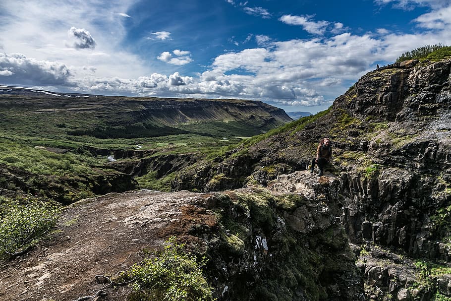 person, bjergklint, klipper, skyer, dagslys, miljø, græs, høj, landskab, bjerge, natur, naturfotografering, udendørs, naturskøn, syn, sidder, kvinde, sky - himmel, bjerg, skønhed i naturen, scenics - natur, ikke-urbane scene, fritidsaktivitet, klippe, rigtige mennesker, dag, solid, rock-objekt, himmel, livsstil, ro, en person, rock formation, rolig scene, bjergkæde, formation, 2K