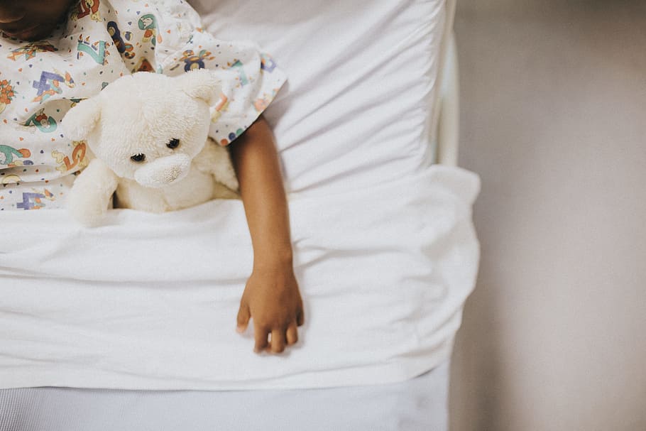 letto, orso, braccio, bambino, coperta, letto d'ospedale, ospedale, malato, malattia, paziente, orsacchiotto di peluche, persona, mano, africano, afroamericano, solo, clinica, nero, assistenza sanitaria, Salute, giocattolo, pupazzo di pezza, mobilia, una persona, Camera da letto, infanzia, in casa, stanza domestica, prole, vista frontale, morbidezza, parte del corpo umano, emozione, volto oscurato, accogliente, innocenza, 5K