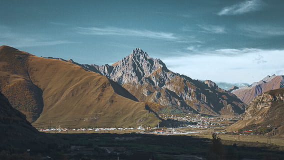 muntanya marró, muntanya, cel blau, rock, ciutat, poble, caminada, paisatge, ombra, llum solar, núvol, aventura, naturalesa, a l'aire lliure, geogrium, kazbegi, jove, vista, vall, vacances, viatge, escenics - natura, cel, bellesa a la natura, núvol - cel, Serra, medi ambient, escena no urbana, dia, escena tranquil·la, cap gent, tranquil·litat, terra, aigua, destinacions de viatge, idíl·lic, formació, 5K, CC0, domini públic, lliure de regalies