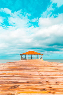 cabana de fusta marró, blau, núvols, la llum del dia, exòtic, cel, idíl·lic, illa, oci, naturalesa, oceà, a l'aire lliure, Camí, recreació, relaxació, Resort, mar, paisatge marí, vora del mar, Riba, estiu, viatjar, tropical, turquesa, vacances, aigua, fusta, núvol - cel, platja, terra, bellesa a la natura, escenics - natura, sorra, dia, estructura construïda, tranquil·litat, arquitectura, escena tranquil·la, cap gent, horitzó sobre l’aigua, refugi, 5K, CC0, domini públic, lliure de regalies
