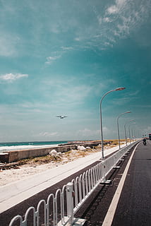 white light post, road, way, highway, vehicle, aircraft, airplane, transportation, tarmac, asphalt, train, guard rail, person, human, handrail, banister, railing, overpass, promontory, intersection, dirt road, sky, sea, street light, cloud - sky, nature, water, the way forward, day, direction, horizon over water, horizon, beach, street, no people, sign, in a row, diminishing perspective, outdoors, crash barrier, 5K, CC0, public domain, royalty free