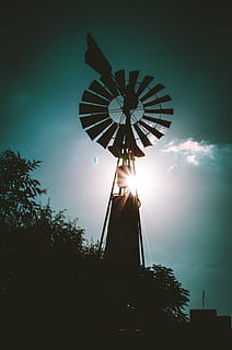 silhouette, farm windmill, backlit, clouds, dark, dawn, electricity, energy, evening, light, low angle shot, scenic, sky, sun, sunset, technology, trees, windmill, low angle view, architecture, nature, tree, no people, night, illuminated, outdoors, built structure, plant, arts culture and entertainment, building exterior, amusement park, amusement park ride, environmental conservation, tall - high, renewable energy, lens flare, 4K, CC0, public domain, royalty free