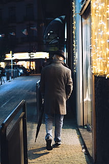man, walking, beside, string lights, apparel, shoe, footwear, clothing, door, person, human, coat, overcoat, car, vehicle, transportation, automobile, hat, umbrella, streetphotography, oldman, elegance, fashion, light, one person, rear view, real people, men, city, architecture, street, building exterior, built structure, full length, illuminated, night, casual clothing, lifestyles, footpath, standing, outdoors, 5K, CC0, public domain, royalty free