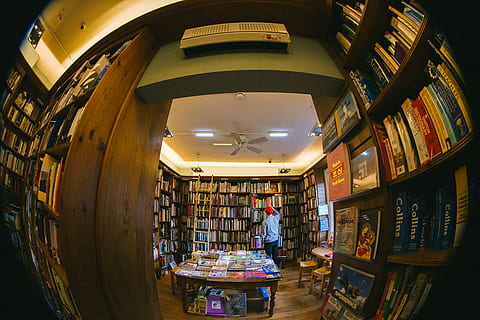 person inside library, furniture, human, person, indoors, shop, book, bookstore, bookcase, room, shelf, interior design, library, lighting, appliance, ceiling fan, fisheye, couch, sphere, spotlight, led, bookshelf, illuminated, real people, one person, publication, lifestyles, retail, architecture, adult, business, store, men, choice, women, market, ceiling, 4K, CC0, public domain, royalty free