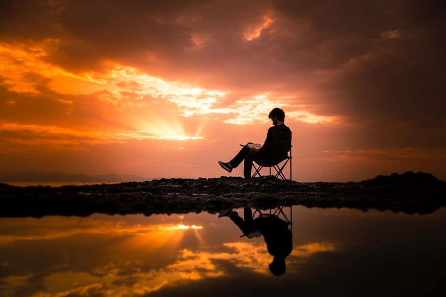 foto, home, assegut, cadira de càmping, alba, cadira, núvols, medi ambient, paio, idíl·lic, oci, masculí, naturalesa, persona, lector, lectura, recreació, reflexió, paisatge, escènic, cel, estiu, sortida del sol, posta de sol, aigua, silueta, color taronja, bellesa a la natura, núvol - cel, escenics - natura, persones reals, una persona, estils de vida, tranquil·litat, escena tranquil·la, activitat d'oci, homes, longitud completa, de peu, sol, a l'aire lliure, 5K